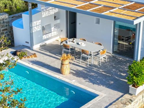 eine Villa mit einem Pool und einem Haus in der Unterkunft Santa Marina Syros in Liaropá
