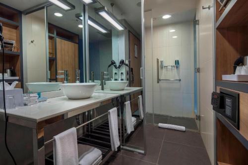 a bathroom with two sinks and a shower at Aloft Bursa Hotel in Bursa
