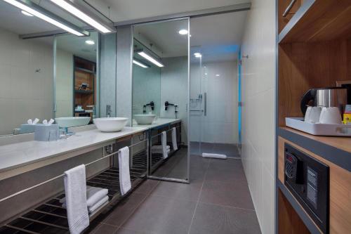 a bathroom with three sinks and a large mirror at Aloft Bursa Hotel in Bursa