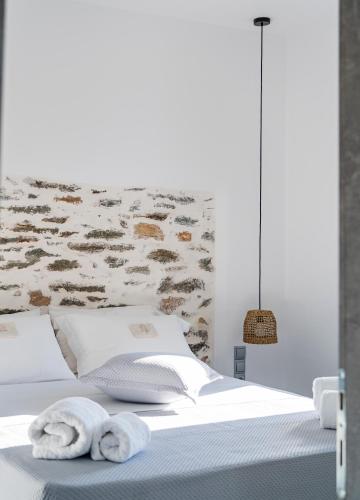 a bedroom with a bed with towels on it at Santa Marina Syros in Liaropá