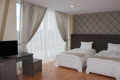 a hotel room with two beds and a television at Family Hotel Silistra in Silistra