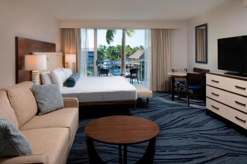 a hotel room with a king sized bed and a living room at Courtyard by Marriott Key Largo in Key Largo