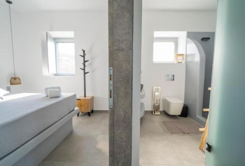 a bedroom with a bed and a bathroom at Santa Marina Syros in Liaropá