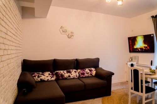 sala de estar con sofá marrón y mesa en Smiling Apartment, en Cluj-Napoca