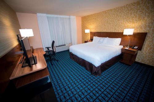 a hotel room with a bed and a flat screen tv at Fairfield Inn & Suites by Marriott Cincinnati Uptown/University Area in Cincinnati
