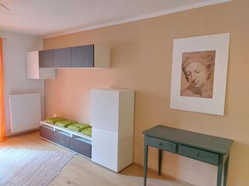 um quarto com uma cama, uma mesa e uma fotografia em Apartment Sonne auf Bio-Hof em Merano