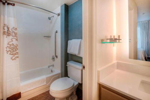 y baño blanco con aseo y ducha. en Residence Inn by Marriott Wilmington Landfall, en Wilmington