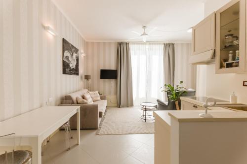 a white kitchen and living room with a couch at Bella Belle Griante in Griante Cadenabbia