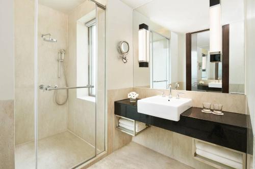 een badkamer met een wastafel en een douche bij Courtyard by Marriott Bandung Dago in Bandung