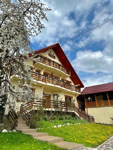 a large building with wooden steps in front of it at Pensiunea Irina Maramureș in Deseşti