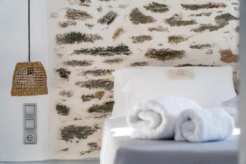 a bedroom with a bed with towels on it at Santa Marina Syros in Liaropá