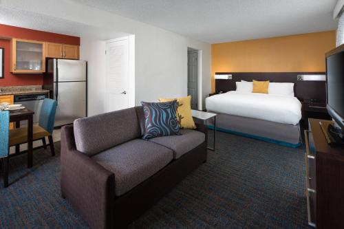 コスタメサにあるレジデンス イン コスタ メサ ニューポート ビーチのベッドとソファ付きの広いホテルルームです。