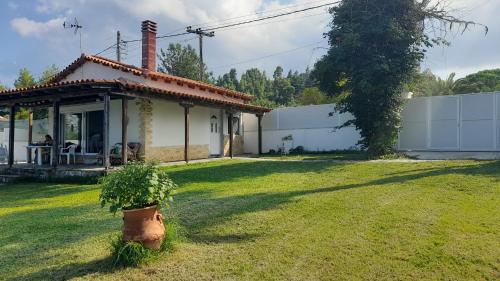 a house with a potted plant in the yard at Olga Studio House in front of the beach in Polykhrono