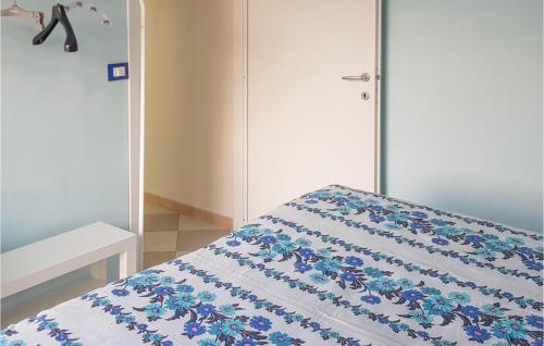 una camera da letto con un letto con fiori blu sopra di Nice Apartment In Petrignano Bivio With Kitchen a Casette