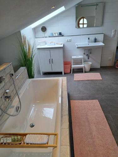 ein großes Bad mit einer Badewanne und einem Waschbecken in der Unterkunft Ferienwohnung Alpenpanorama in Halblech
