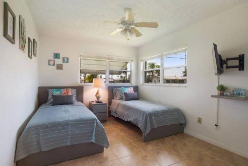 a bedroom with two beds and a ceiling fan at Villa Holiday Sunrise II in Cape Coral