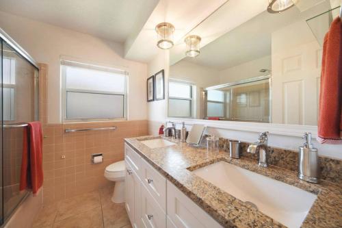 a bathroom with a sink and a toilet and a mirror at Villa Holiday Sunrise II in Cape Coral
