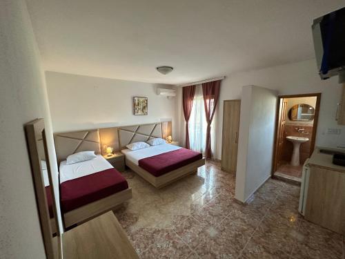 a hotel room with two beds and a television at Apartments Near The Coast - Milla in Ulcinj