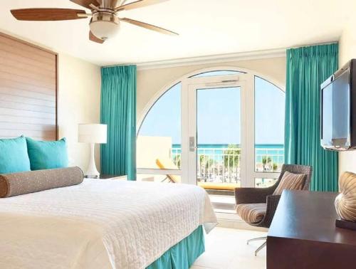 Bluegreen at La Cabana Beach Resort & Casino في شاطئ بالم إيغل: غرفة نوم مع سرير وإطلالة على المحيط