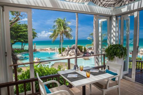 a table and chairs on a balcony with a view of the ocean at Sheraton Samui Resort in Chaweng Noi Beach
