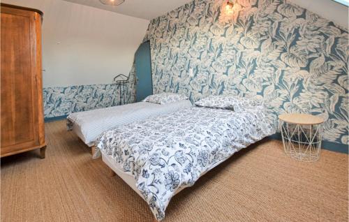 a bedroom with a bed and a blue and white wallpaper at 4 Bedroom Cozy Home In Montsenelle in Lithaire