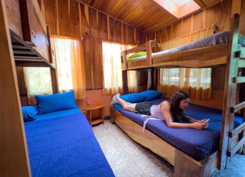 una donna sdraiata su un letto in una camera con letti a castello di Casa Tranquilo Hostel a Monteverde Costa Rica