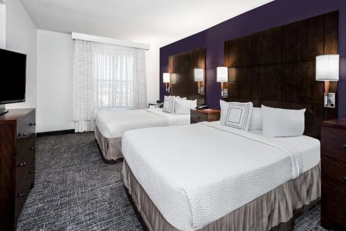 a hotel room with two beds and a flat screen tv at Residence Inn by Marriott San Antonio SeaWorld / Lackland in San Antonio