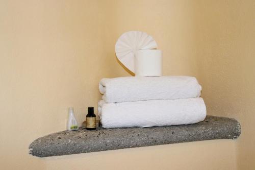 a stack of towels on a shelf with a mirror at Hotel Chocolate Suites in Guanajuato