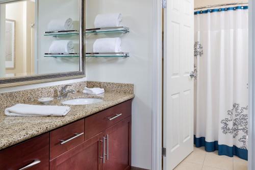 y baño con lavabo, espejo y ducha. en Residence Inn by Marriott Houston The Woodlands/Lake Front Circle en The Woodlands