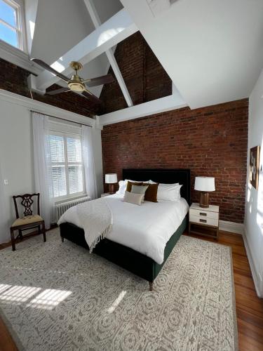 a bedroom with a large bed and a brick wall at The Boulevard Inn in Richmond