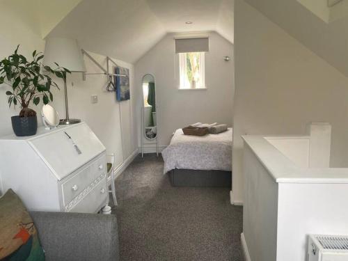 a white bedroom with a bed and a window at Rural cosy retreat for two near Port Isaac in Delabole