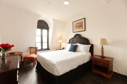 a bedroom with a bed and a desk and a chair at Le Richelieu in the French Quarter in New Orleans