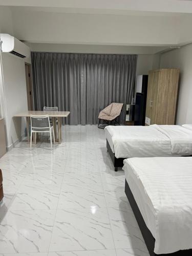 a hotel room with two beds and a table at Mall Suites Hotel in Bangkok