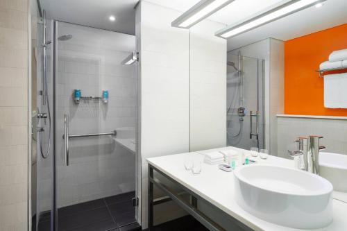 a bathroom with a sink and a shower at Aloft Riyadh Hotel in Riyadh