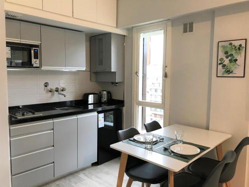 a small kitchen with a table and a table and chairs at Via Buenos Aires- Studio Microcentro in Buenos Aires