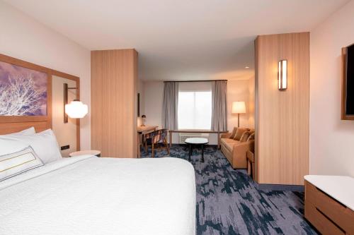 a hotel room with a bed and a living room at Fairfield Inn & Suites by Marriott Fair Oaks Farms in Fair Oaks