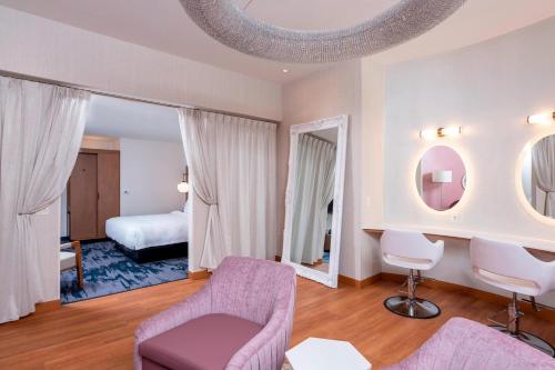 sala de estar con silla púrpura y dormitorio en Fairfield Inn & Suites by Marriott Fair Oaks Farms en Fair Oaks