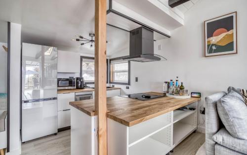 a kitchen with white cabinets and a wooden counter top at Seabatical on The Strand - Meredith Lodging in Rockaway Beach