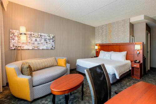 a hotel room with a bed and a couch and a table at Courtyard Philadelphia Great Valley/Malvern in Malvern