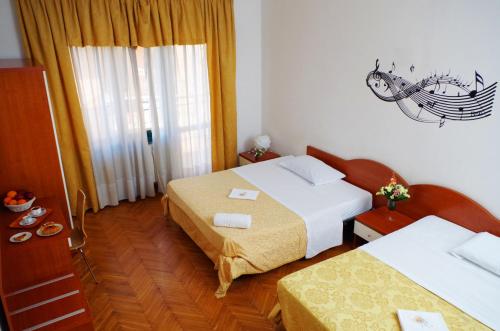 a hotel room with two beds and a window at Hotel Centrale in Milan