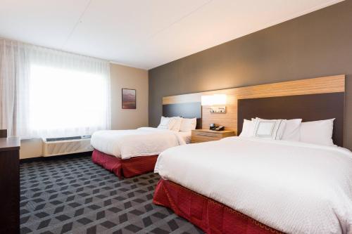 a hotel room with two beds and a window at TownePlace Suites by Marriott Edmonton South in Edmonton