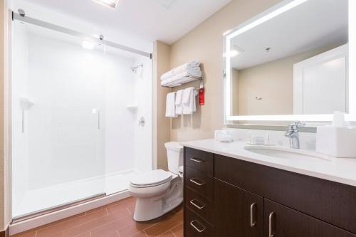 a bathroom with a sink and a toilet and a mirror at TownePlace Suites by Marriott Edmonton South in Edmonton