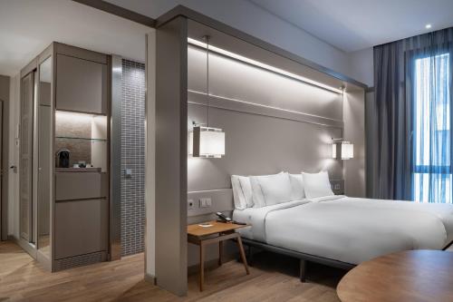 AC Hotel Recoletos by Marriott في مدريد: غرفة الفندق بسرير وطاولة