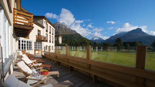 a deck with chairs and a view of mountains at Maloja Palace Residence Engadin-St Moritz CO2-Neutral in Maloja