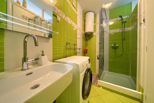 a green bathroom with a sink and a shower at Apartment Frane in Baška