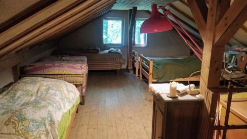 a attic room with two beds and a lamp at Waldhaus auf dem Randen, Kanton Schaffhausen 