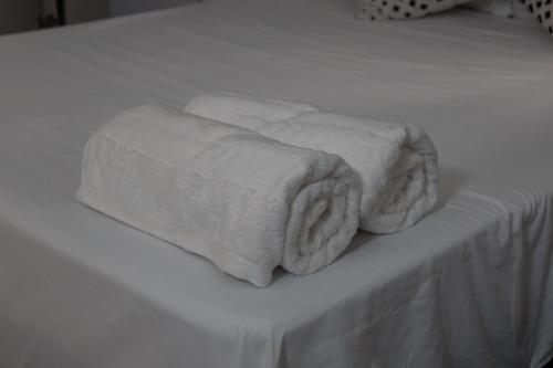dwa ręczniki są ułożone na białym łóżku w obiekcie Apartamentos Vacacional Cartagena cerca Aeropuerto y Playa w mieście Cartagena de Indias