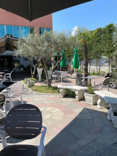 a patio with chairs and tables and umbrellas at Bajovah Apartments & Restaurant in Tirana