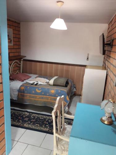 1 dormitorio con cama y mesa azul en Hotel Pousada Casa Nostra en Erechim