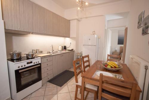 a kitchen with a table and a white stove top oven at Apartment with view in Kiveri, near Nafplio in Kivérion